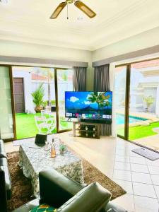 sala de estar con TV de pantalla grande y sofá en Pattaya Jomtien Private Luxury Pool Villa 芭堤雅中天豪华私家泳池别墅, en Jomtien Beach