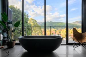 a large bath tub in a room with a large window at The View Bright - Apartment 1 in Bright