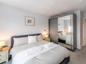 a bedroom with a large white bed and a mirror at Pass the Keys 40C 2 bed Celosia Beautiful Town Centre Apartment in Shrewsbury