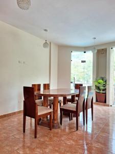 - une salle à manger avec une table et des chaises en bois dans l'établissement Casa de Campo con Piscina, à Tingo María