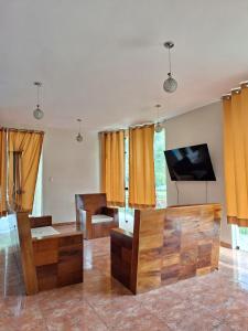 a living room with orange curtains and a tv at Casa de Campo con Piscina in Tingo María