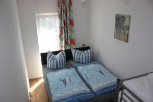 a bedroom with a bed with two pillows and a window at zum Dünengras in Saal