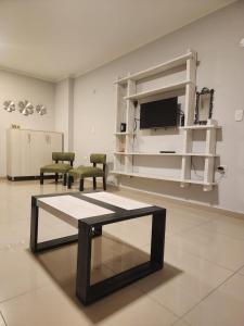 um quarto com uma mesa e duas cadeiras e uma televisão em Departamento Quality Belgrano em Santiago del Estero