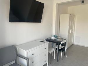 a room with a desk and a dresser with a table at Pensjonat VICTORIA in Ustka