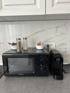 a black microwave with two bowls on top of it at Fortress Apartament in Oradea