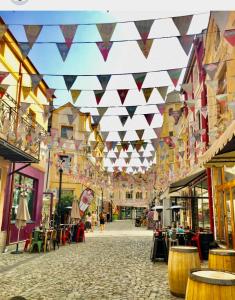 a street with flags hanging from the ceilings of a building at Апартаменти Стефани in Plovdiv