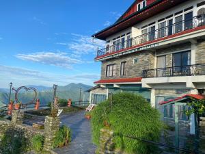 a building with a table and chairs in front of it at Panoramic View Guest House Sarangkot in Pokhara