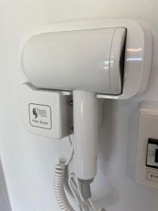 a white hair dryer in a bathroom at Khaolak Mind Home Hostel in Khao Lak