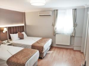 イスタンブールにあるHotel Süreyyaのベッド2台と窓が備わるホテルルームです。