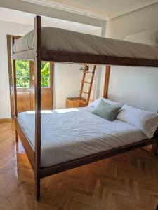 a bedroom with a bunk bed with a ladder at Piso Grande La Viña in Biescas +12 photos