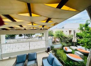 a patio with chairs and tables on a balcony at Ella Willa Suite House Butik Otel in Gure