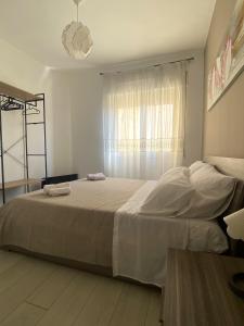 um quarto com uma cama grande e uma janela em Da Grazia Napoli Apartment em Nápoles