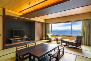 - un salon avec une table et une grande fenêtre dans l'établissement 焼津グランドホテル, 