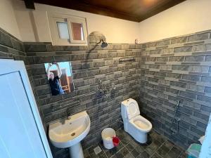 a bathroom with a sink and a toilet and a urinal at Panoramic View Guest House Sarangkot in Pokhara