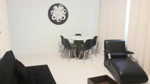 uma sala de jantar com uma mesa e cadeiras pretas em Flat Praia de Icaraí, 2 qts, 1vaga garagem e piscina em Niterói