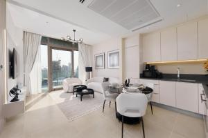 杜拜的住宿－Maison Privee - Modern Luxury Apt with Spectacular Dubai Marina Vws，厨房以及带桌椅的起居室。