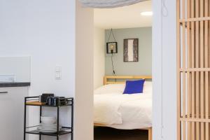 um quarto com uma cama com uma almofada azul em City Apartment Dornbirn, Hongkong 1 em Dornbirn