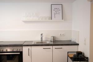 a kitchen with a sink and a counter top at City Apartment Dornbirn, Hongkong 1 in Dornbirn +5 photos