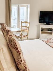 a bedroom with a bed and a table and a television at Auberge de l'Abbaye Cruis in Cruis