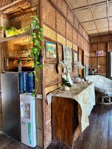 a kitchen with a refrigerator and a table in a trailer at Bamboo House Beach Lodge & Restaurant in Puerto Galera