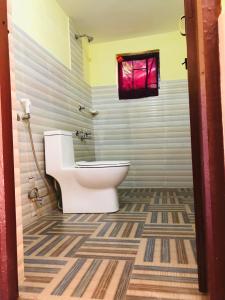 een badkamer met een toilet en een raam bij Nature Safari Resort in Bhurkīā