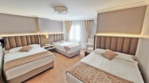 a hotel room with two beds and a desk at Hotel Süreyya in Istanbul