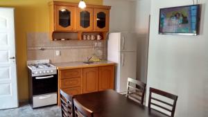 كابانياس إنسوينيو ديل لاغو في ترماس دي ريو هوندو: مطبخ مع طاولة وثلاجة بيضاء