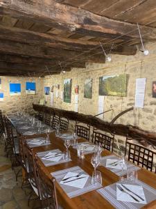 a long dining room with wooden tables and chairs at Auberge de l'Abbaye Cruis in Cruis
