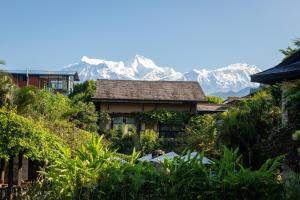 a house with a mountain in the background at Temple Tree Resort & Spa in Pokhara