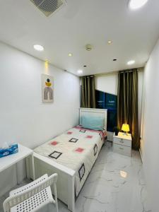 a small bedroom with a bed and a desk at DSV Property in Abu Dhabi