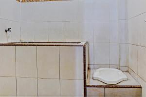uma casa de banho com um WC branco numa prateleira em OYO 93108 Homestay H Syarif Syariah – RA Kartini em Gresik