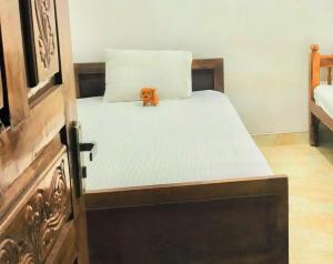 a bed with a teddy bear sitting on top of it at Grand Refuge Holiday Rooms in Anuradhapura