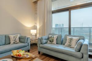 a living room with two blue couches and a large window at BEAUTIFUL HUGE 2 BED ROOM APARTMENT in Dubai