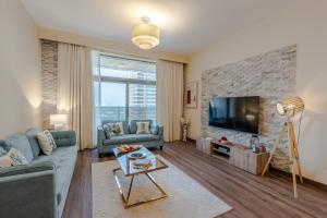 a living room with a couch and a tv at BEAUTIFUL HUGE 2 BED ROOM APARTMENT in Dubai