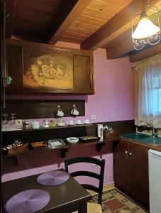 - une cuisine avec des murs roses, une table et un évier dans l'établissement Ξενώνας Λίκνο, à Synikia Mesi Trikalon