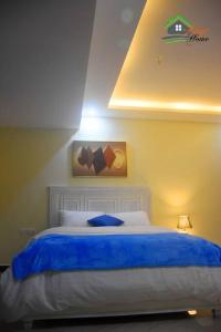 a bedroom with a bed with a blue blanket at Bright cozy APT in the heart of Naguru in Kampala