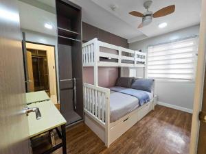 a bedroom with a bunk bed and a desk at Stylish 2 Bedroom Condo Near BGC and Airport with Fast WiFi in Manila +25 photos