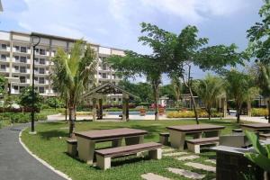 a park with benches in front of a building at Stylish 2 Bedroom Condo Near BGC and Airport with Fast WiFi in Manila