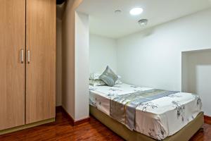 - une chambre avec un lit et une armoire dans l'établissement Guangzhou Manhattan International Apartment Zhengjia Branch, à Canton