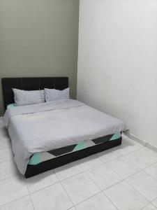 a bedroom with a bed with a black headboard at June's Homestay@ Puteri Wangsa near Aeon & IKEA in Ulu Tiram