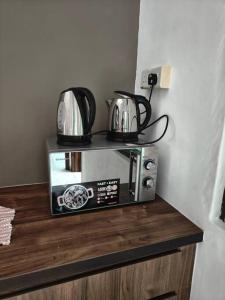 a microwave with two pots and pans on top of it at June's Homestay@ Puteri Wangsa near Aeon & IKEA in Ulu Tiram