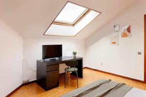 a bedroom with a desk with a television and a skylight at Coto Salinas Apartamento in Salinas