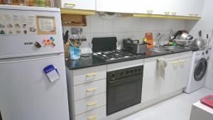 a kitchen with a stove and a refrigerator at Habitacions Cal Gueles in Sanahuja