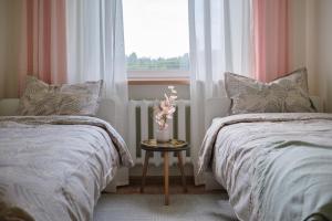 une chambre avec deux lits et une fenêtre dans l'établissement Resort Stories Išskirtiniai 7 vietų apartamentai Birštone, à Birštonas