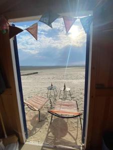 two chairs and a table on the beach at Maison Plage à 50m, Centre Ville avec sa cabine de plage in Le Crotoy +6 photos