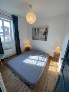 a bedroom with a bed in the corner of a room at Maison Plage à 50m, Centre Ville avec sa cabine de plage in Le Crotoy