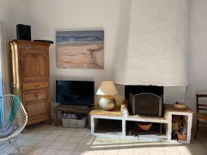 a living room with a tv and a table at Maison Plage à 50m, Centre Ville avec sa cabine de plage in Le Crotoy