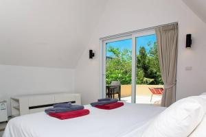 a bedroom with a white bed with red towels on it at Siam Beach Villa 21D Koh Chang in Ko Chang