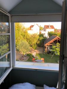 a window in a bedroom with a view of a yard at Chambre double avec salle de bain privative in Auxerre