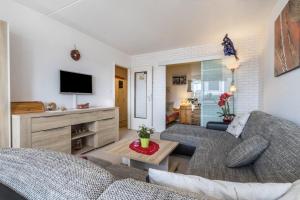 Una sala de estar con un sofá y un televisor. en Harzblick, en Altenau